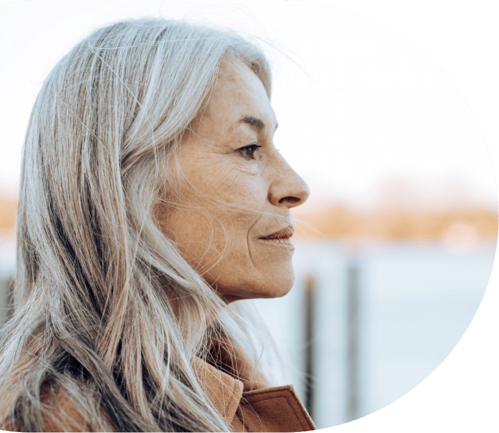 older woman staring out at a bay or a lake while struggling with senior depression symptoms