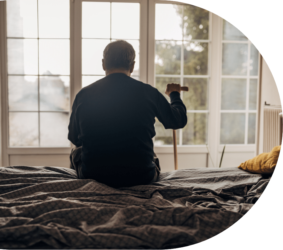 elderly man sitting on his bed while he struggles with depression in seniors