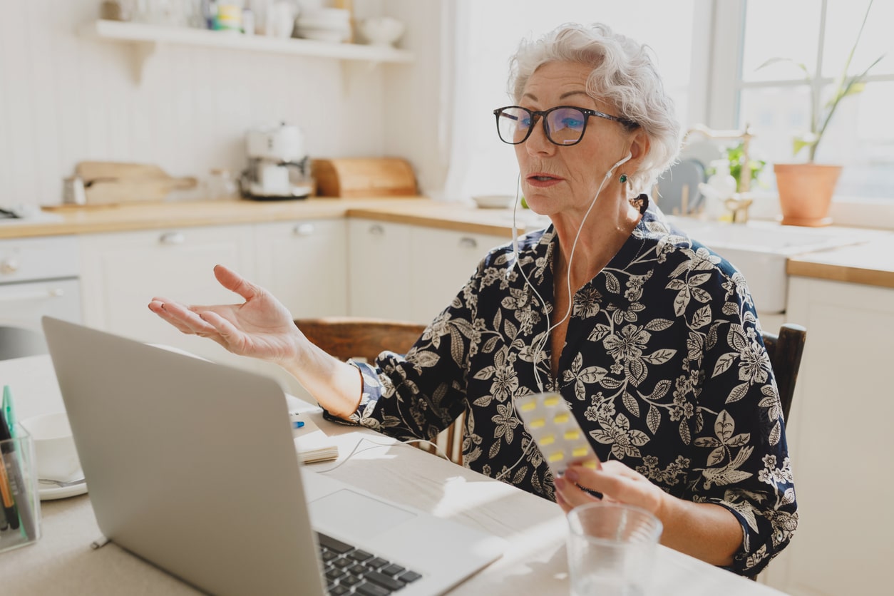 Older woman sitting at a desk and learning about what Medicare is