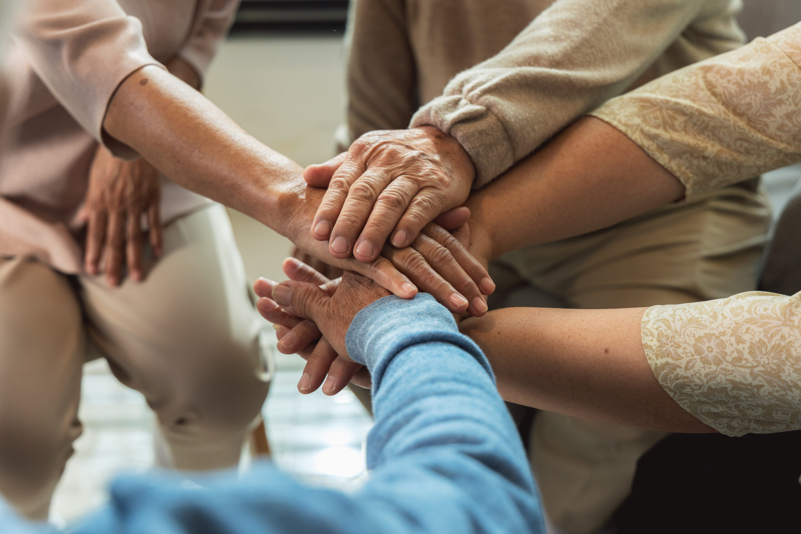 Group of elderly people joining hands together